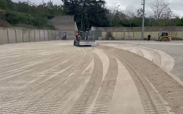 Curve concentriche tracciate dalla livellatrice nella sabbia